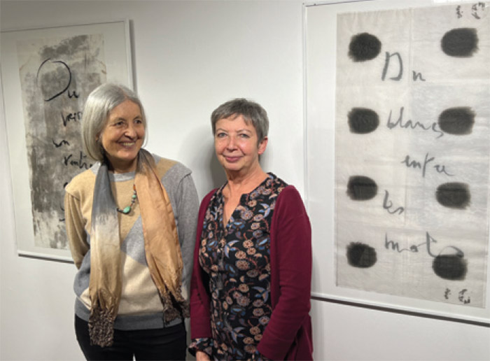 L’artiste Catherine Fontaine (à gauche) et Anne-Marie Bressollier, de la direction culturelle de la ville de Lorient (à droite), devant des calligraphies sur papier du Japon.